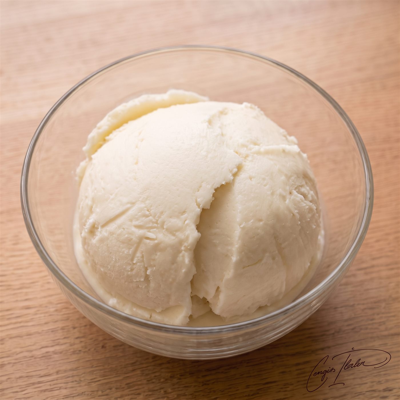 A dense, glossy scoop of white dondurma in a glass bowl.