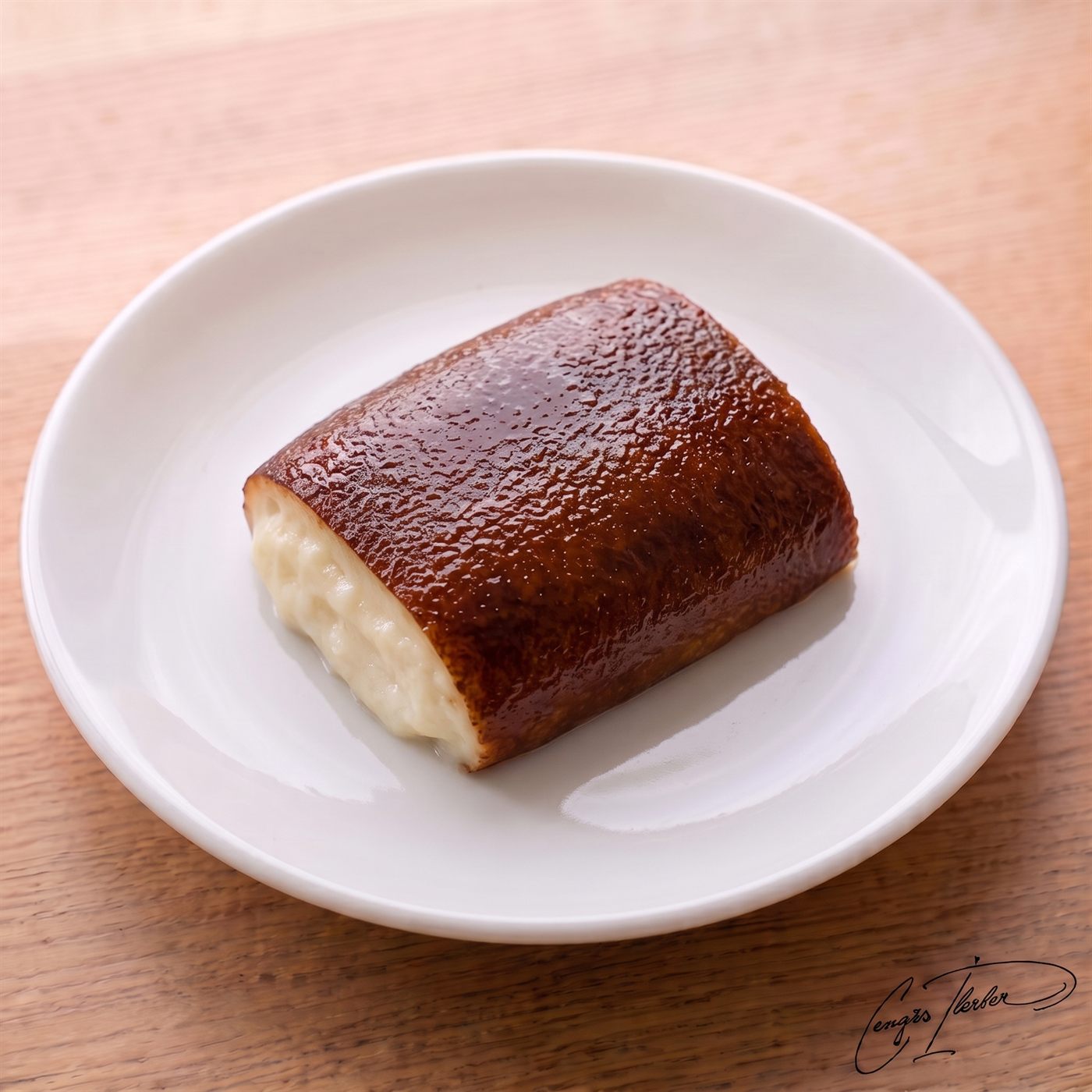 A rectangular slice of Turkish kazandibi (caramelized milk pudding) on a white plate, showcasing its signature dark, beautifully caramelized top.