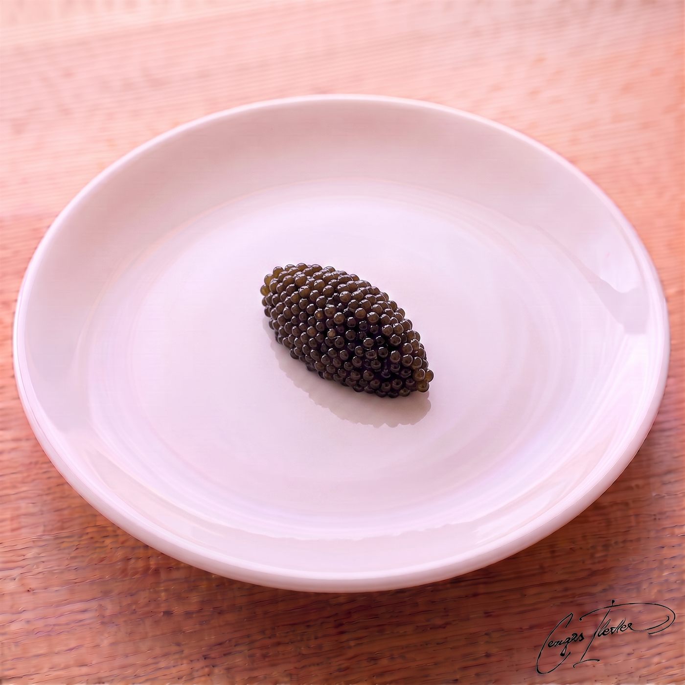A small mound of glistening black caviar carefully plated on a simple white dish.